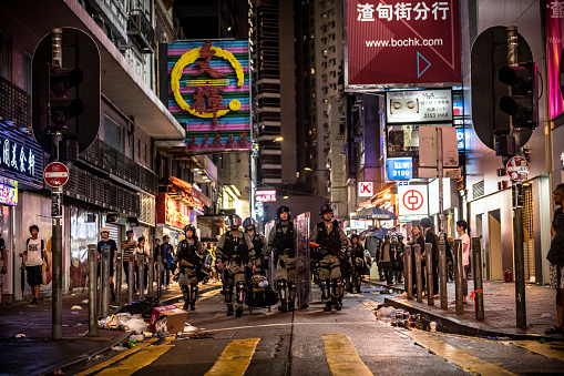 Hong Kong riot police walk together down a road near Causeway Bay MTR station on Hong Kong Island (August 31, 2019)