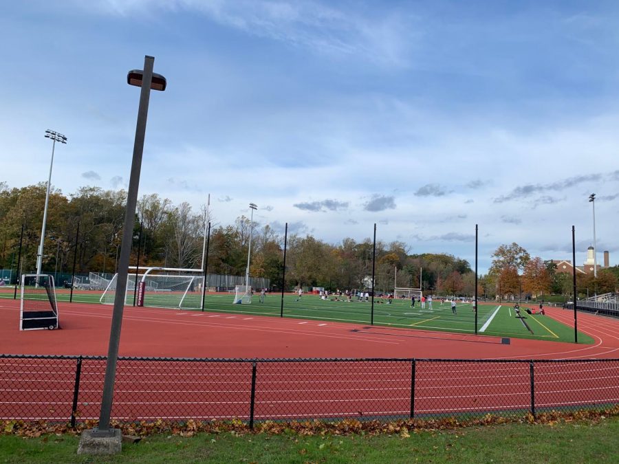 Students intermix with other cohorts on the Scarsdale High School field.