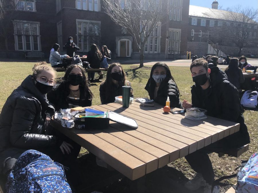 Scarsdale High School students eating lunch outdoors while enjoying the early spring weather.