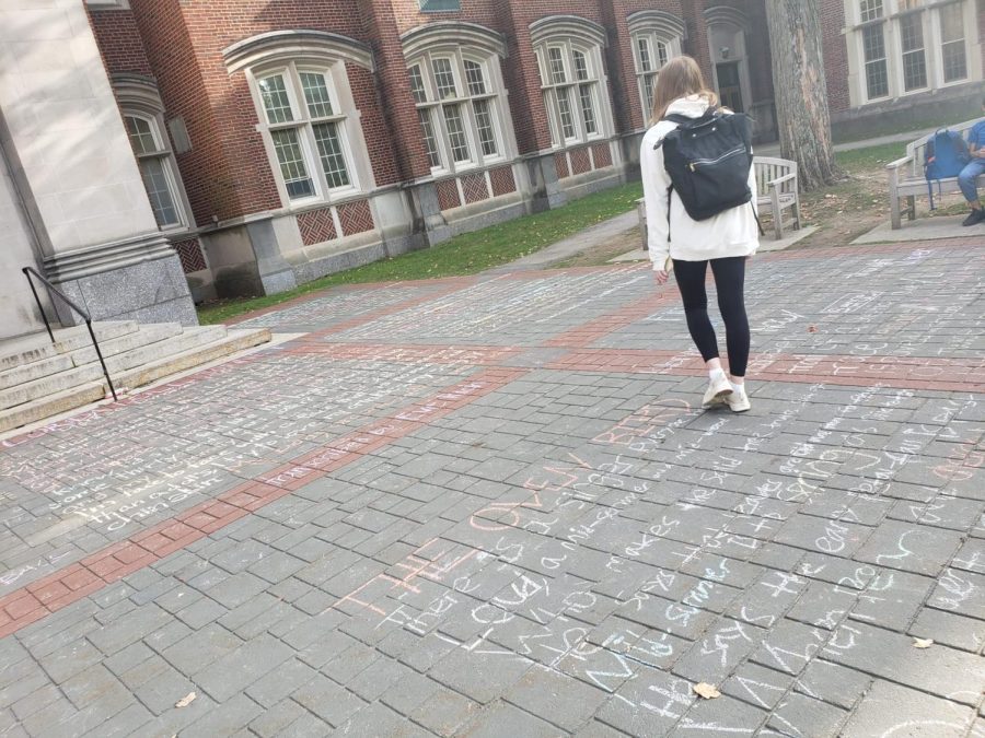 SHS student admiring the chalked sonnets on the floor of the school.