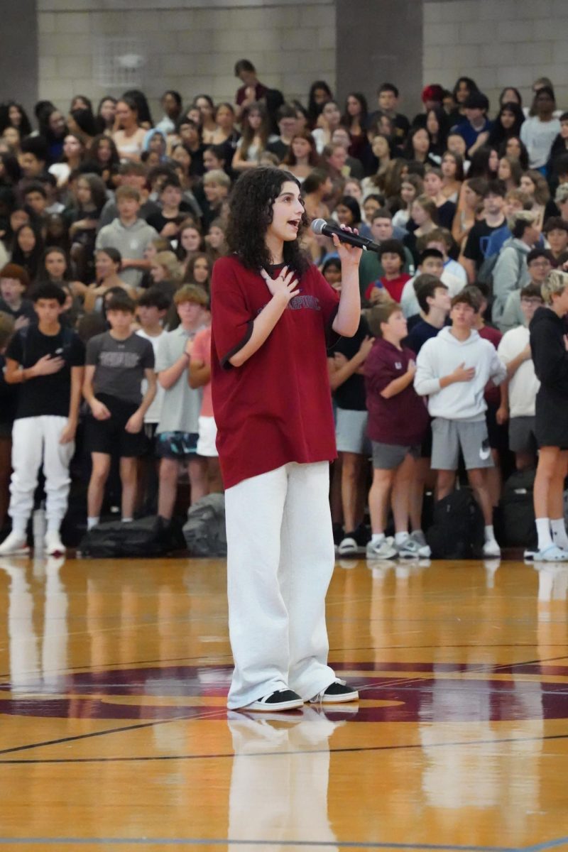 Uma S. singing the national anthem to begin the pep rally. 