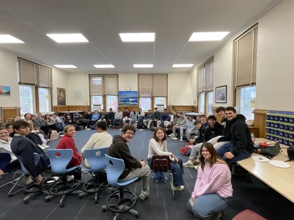 People in the House Meeting arranged in a circle, smiling for a picture.