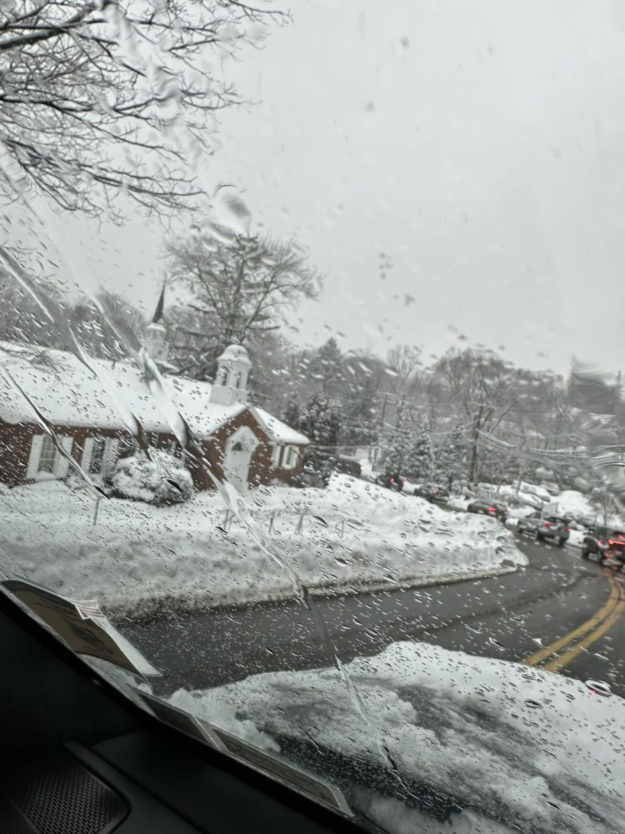 Snow accumulates as rain and sleet blur the view from inside a vehicle.