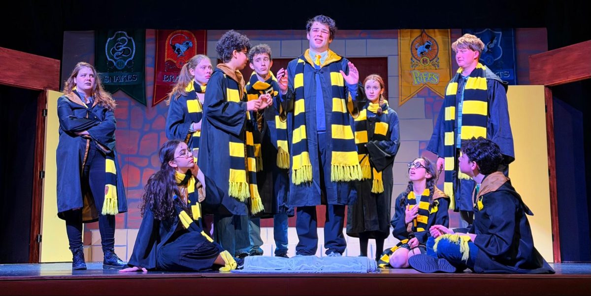 Cedric Diggory (Peter Robelen '27) is lauded and admired by the Hufflepuffs, showcasing his role as the much-praised hero of the original Harry Potter.