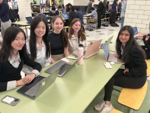 Various members of the debate team sit in the Bronx Science building, preparing for an upcoming round.