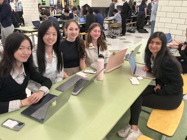 Various members of the debate team sit in the Bronx Science building, preparing for an upcoming round.