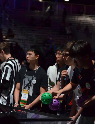 Team captains Kevin Han '26 (left) and Nathan Tao '26 (center) preparing game pieces before the start of their match
