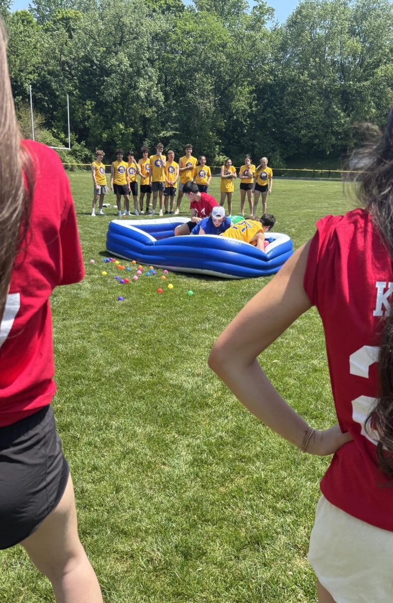 Four teams participate in "Steal the Bacon," a game in which they must rush to the center and grab a specific object from the kiddie pool.